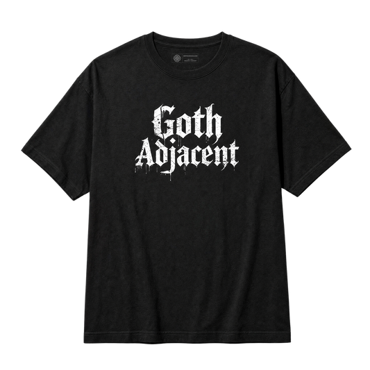 A black short-sleeve crewneck t-shirt featuring the phrase 'Goth Adjacent' printed in a distressed white Gothic font across the chest, displayed on a solid white background.